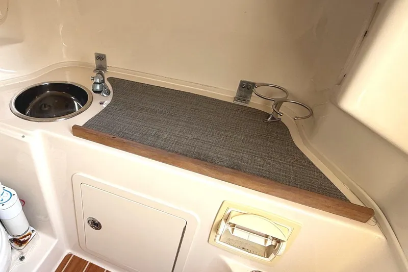 Slide: The Image of 2018 Grady-White Canyon 306 boat interior with sink and storage area. - 28