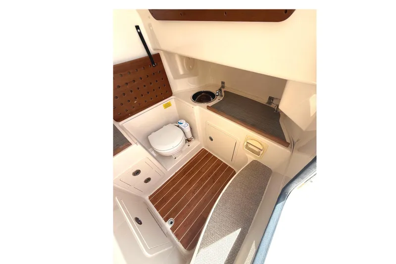 Slide: The Image of 2018 Grady-White Canyon 306 boat interior with toilet, sink, and wooden flooring. - 29