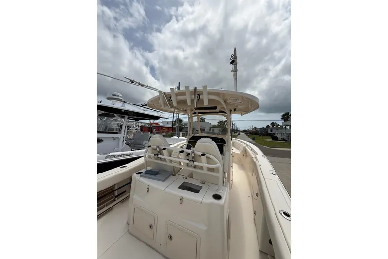 Slide: The Image of 2018 Grady-White Canyon 306 boat with center console and seating, under cloudy sky. - 38
