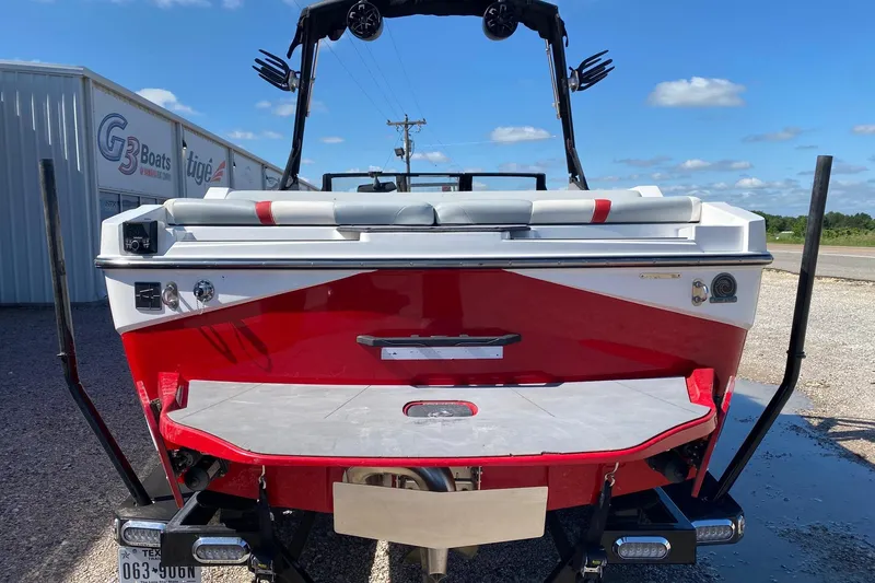 Slide: The Image of 2023 Axis T220 boat, red and white, rear view with trailer, parked outdoors. - 5
