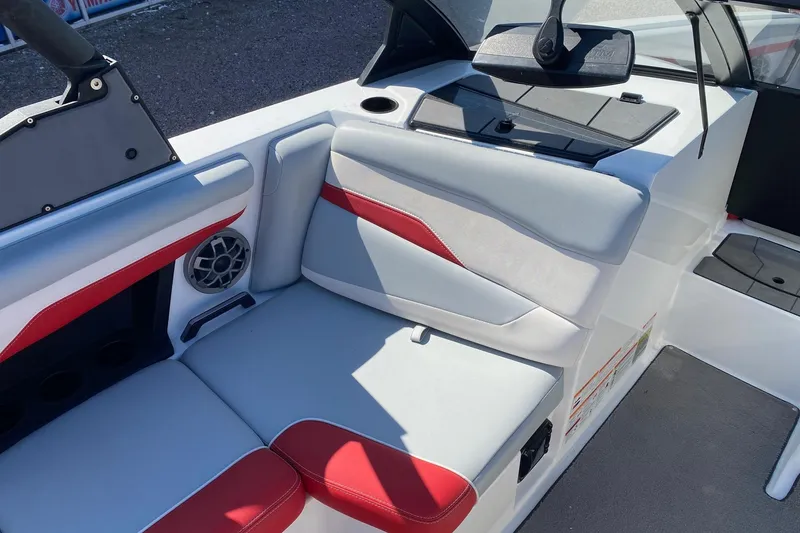 Slide: The Image of 2023 Axis T220 boat interior with red and white seating, speaker, and storage compartment. - 9