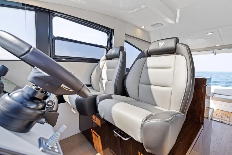Slide: The Image of 2025 Fairline Targa 50 GT interior with luxurious leather seating and modern steering wheel. - 28