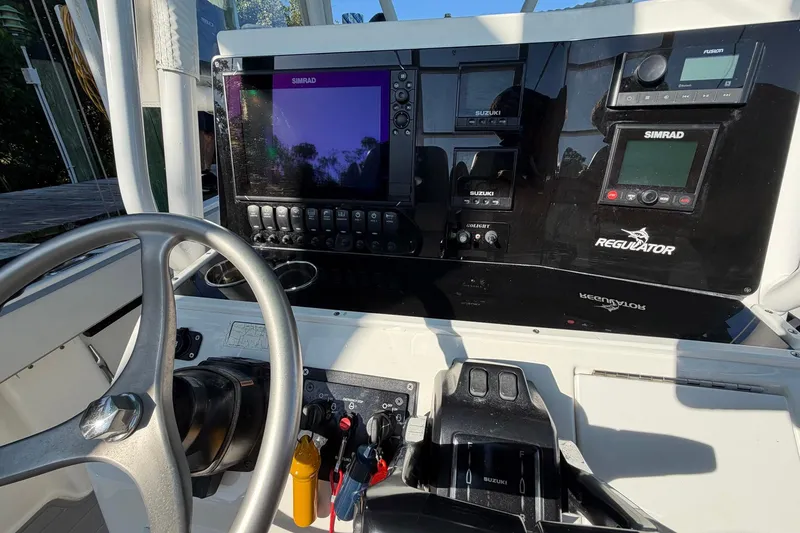 Slide: The Image of 2002 Regulator 26 Center Console dashboard with Simrad electronics and steering wheel. - 12