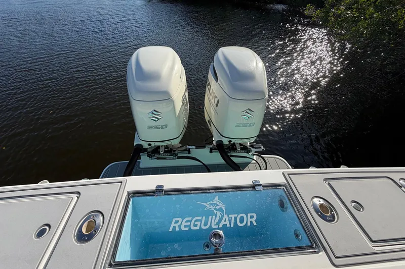 Slide: The Image of 2002 Regulator 26 Center Console boat with twin Suzuki 250 engines on water. - 19