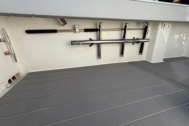 Slide: The Image of 2002 Regulator 26 Center Console boat deck with rod holders and cleat. - 22
