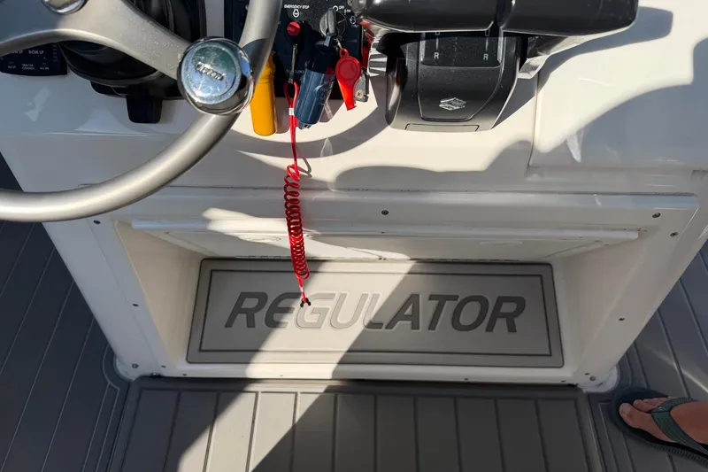 Slide: The Image of 2002 Regulator 26 Center Console boat dashboard with steering wheel and controls. - 23