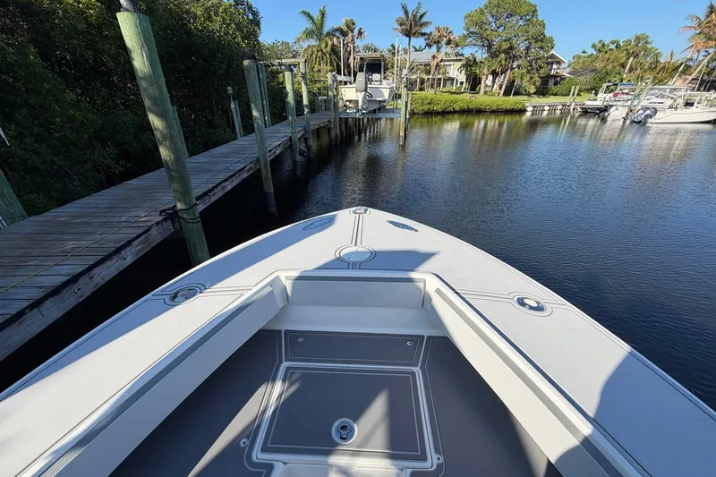 Slide: The Image of 2002 Regulator 26 Center Console boat docked in a serene marina setting. - 4