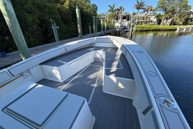 Slide: The Image of 2002 Regulator 26 Center Console boat docked by a serene waterfront. - 5