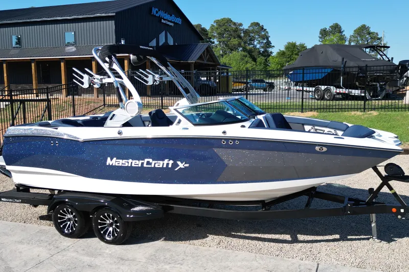 The Image of 2021 MasterCraft XStar boat on trailer, parked outside dealership. - 1