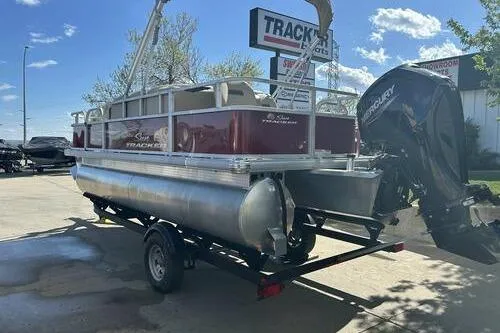 Slide: The Image of 2025 Sun Tracker Bass Buggy 18 DLX pontoon boat on trailer, outdoor dealership setting. - 3