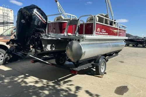 Slide: The Image of 2025 Sun Tracker Bass Buggy 18 DLX pontoon boat on trailer, featuring Mercury outboard motor. - 4
