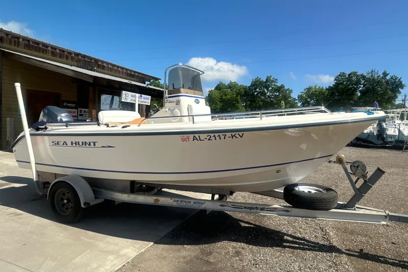 The Image of 2005 Sea Hunt Triton 186 boat on trailer, parked outdoors under clear blue sky. - 0