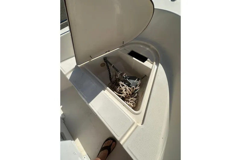 Slide: The Image of Open storage compartment on 2005 Sea Hunt Triton 186 boat, containing anchor and rope. - 13