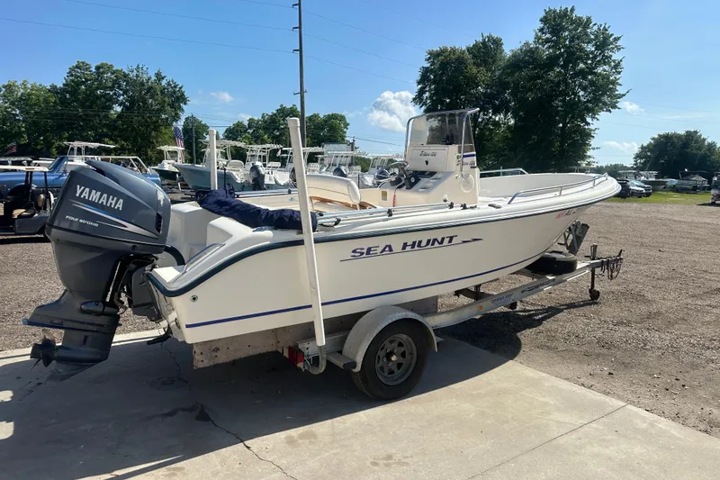 Slide: The Image of 2005 Sea Hunt Triton 186 boat with Yamaha engine on trailer, parked outdoors. - 2