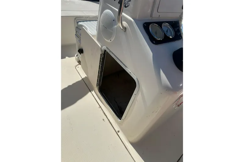 Slide: The Image of 2005 Sea Hunt Triton 186 boat console with open storage compartment and gauges. - 25