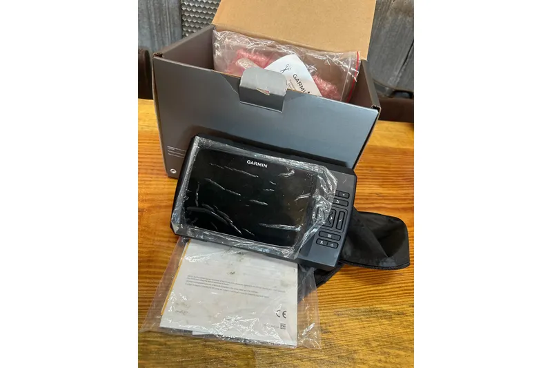 Slide: The Image of Garmin device with packaging and manual on wooden surface, suitable for Sea Hunt Triton 186. - 28