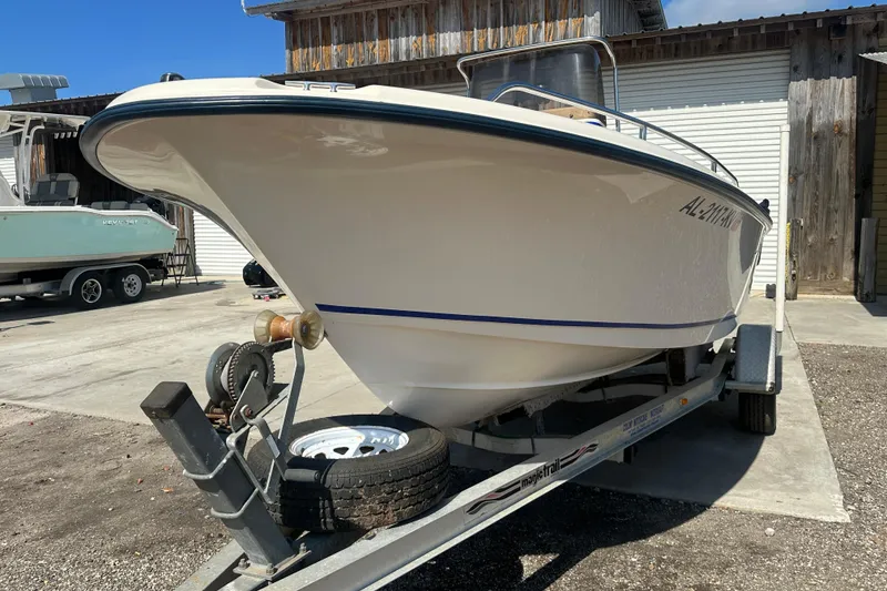 Slide: The Image of 2005 Sea Hunt Triton 186 boat on trailer, parked outdoors near wooden building. - 5