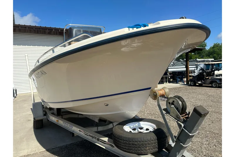 Slide: The Image of 2005 Sea Hunt Triton 186 boat on trailer, parked outdoors under clear blue sky. - 6