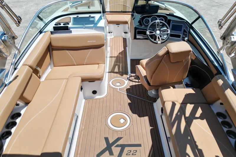 Slide: The Image of 2020 MasterCraft XT22 boat interior with tan seating and modern dashboard. - 10