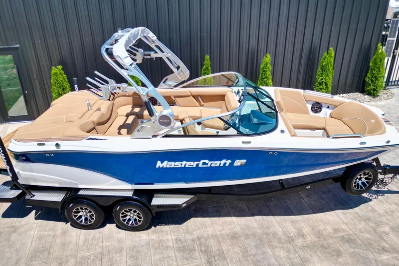 Slide: The Image of 2020 MasterCraft XT22 boat with blue and white exterior on a trailer. - 5