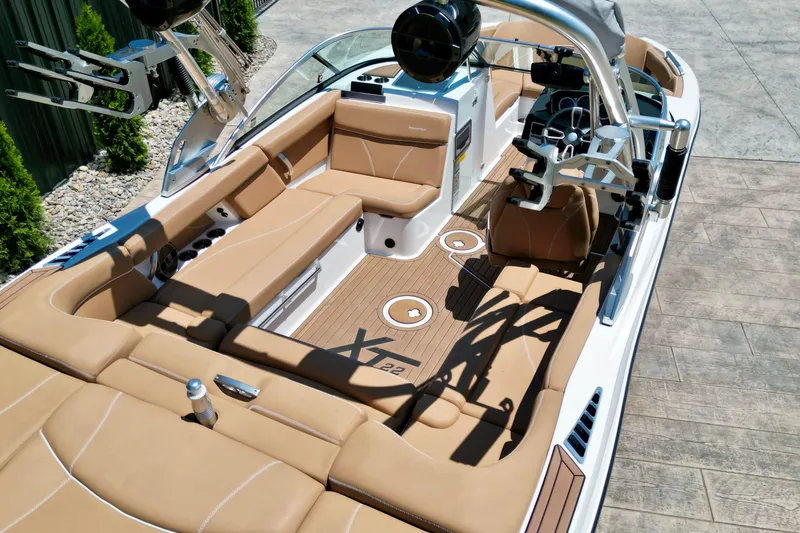 Slide: The Image of 2020 MasterCraft XT22 boat interior with tan seating and modern dashboard design. - 8