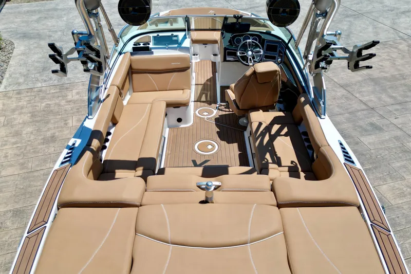 Slide: The Image of 2020 MasterCraft XT22 boat interior with tan seating and modern dashboard design. - 9
