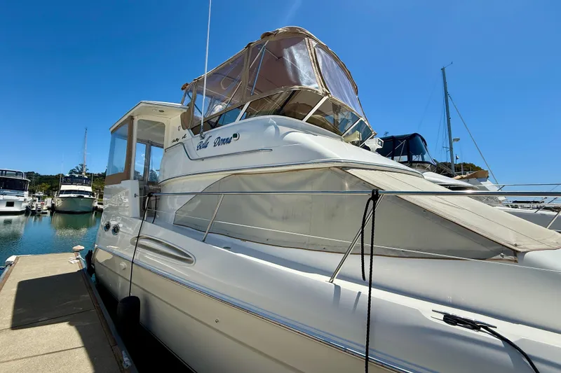 Slide: The Image of 2000 Sea Ray 380 Aft Cabin yacht docked at marina under clear blue sky. - 2