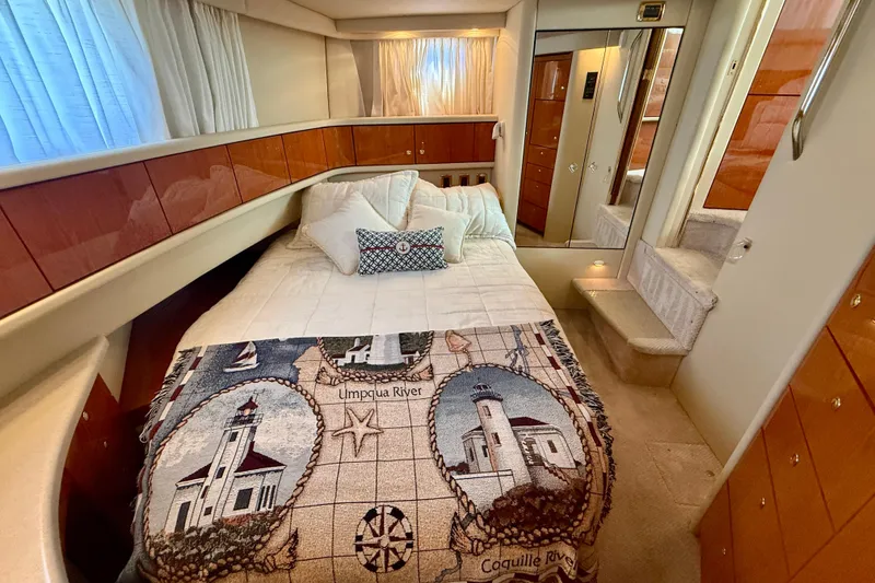 Slide: The Image of Luxurious 2000 Sea Ray 380 Aft Cabin bedroom with nautical-themed decor and cozy bedding. - 24
