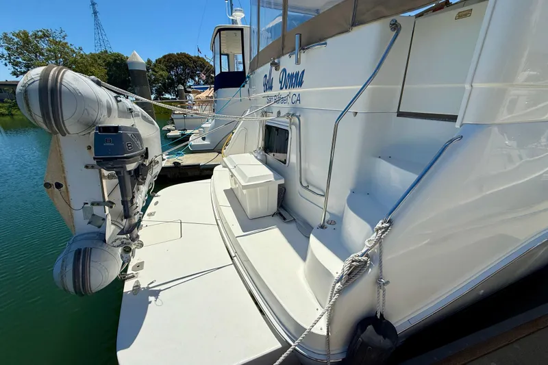 Slide: The Image of 2000 Sea Ray 380 Aft Cabin yacht with dinghy, docked in a marina. - 3