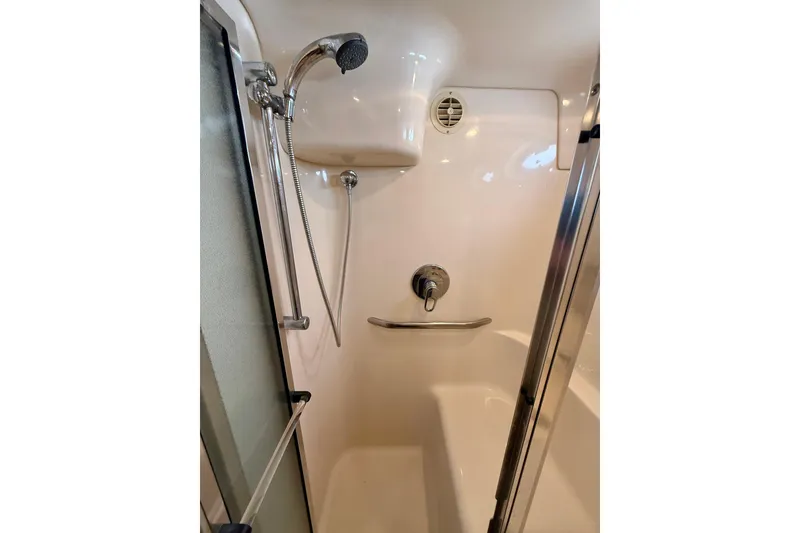 Slide: The Image of Shower area in 2000 Sea Ray 380 Aft Cabin yacht, featuring chrome fixtures and glass door. - 36