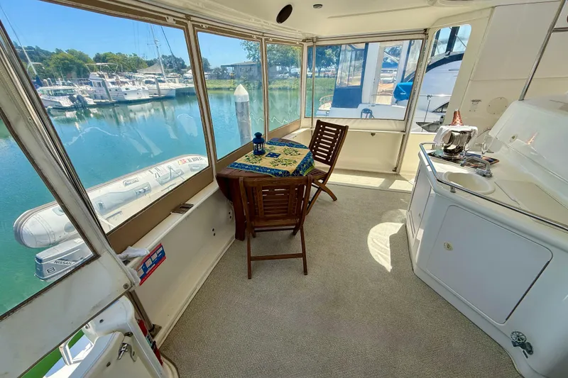 Slide: The Image of Interior of 2000 Sea Ray 380 Aft Cabin yacht with dining area and marina view. - 6