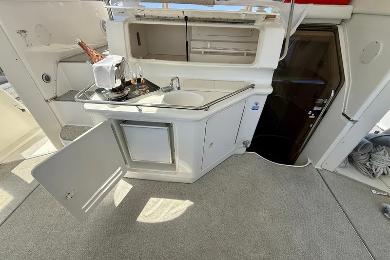 Slide: The Image of 2000 Sea Ray 380 Aft Cabin yacht interior with kitchenette and open cabinet. - 7
