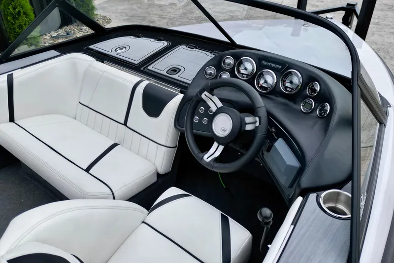 Slide: The Image of Interior of a 1994 Nautique Ski Nautique boat with sleek dashboard and white seating. - 10