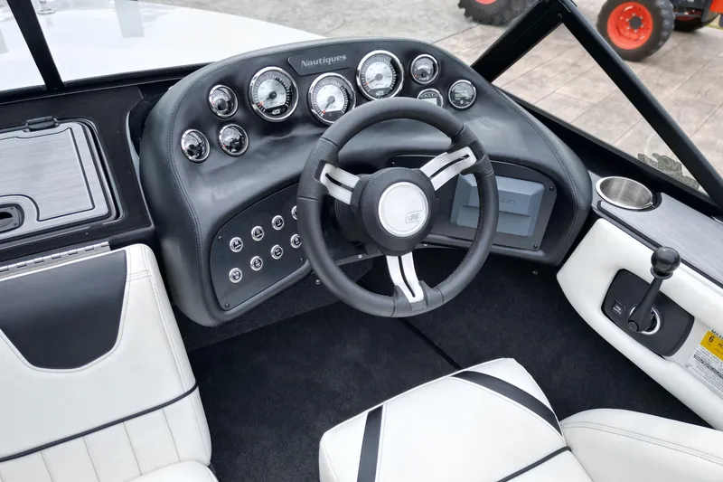 Slide: The Image of 1994 Nautique Ski Nautique boat dashboard with steering wheel and control panel. - 13