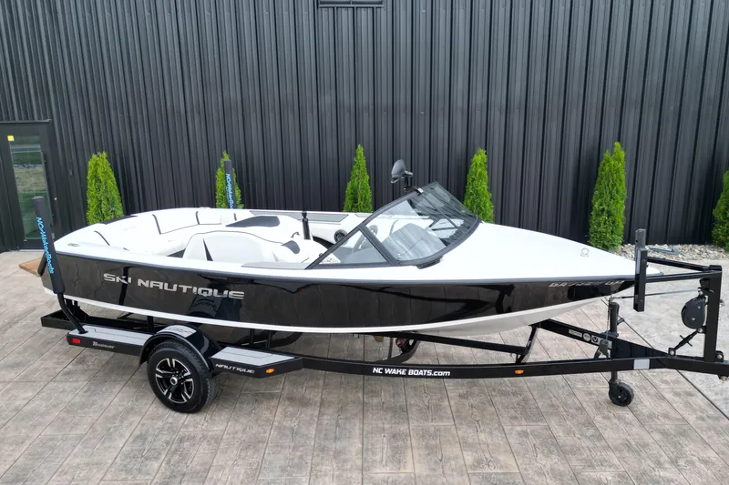 Slide: The Image of 1994 Nautique Ski Nautique boat on trailer, black and white design, parked outdoors. - 3