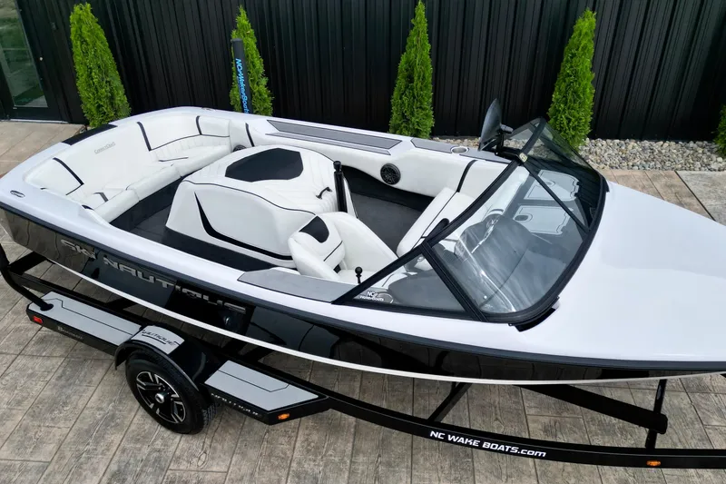 Slide: The Image of 1994 Nautique Ski Nautique boat with sleek black and white design on a trailer. - 5