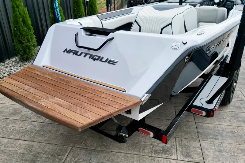 Slide: The Image of 1994 Nautique Ski Nautique boat with wooden swim platform, parked on a trailer. - 7