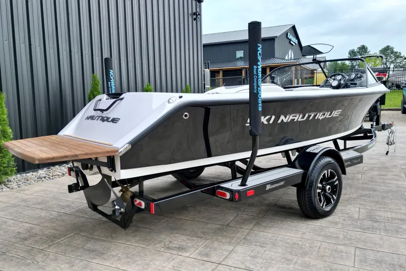 Slide: The Image of 1994 Nautique Ski Nautique boat on trailer, sleek design, parked outdoors. - 8