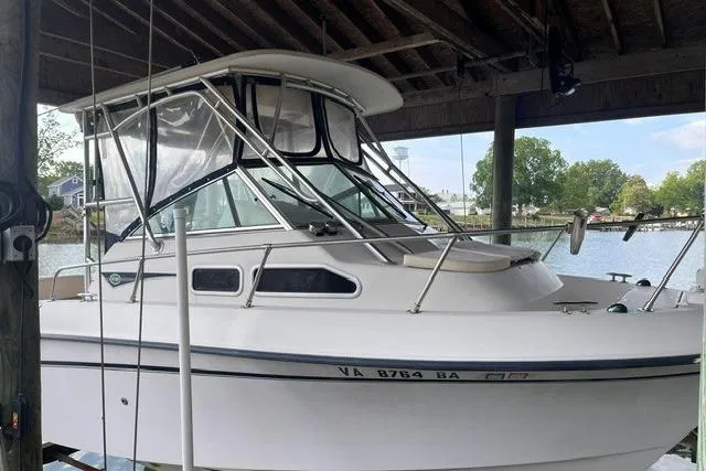 The Image of 2002 Grady-White Gulfstream 232 boat docked under a wooden shelter. - 0