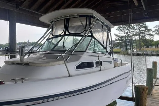 Slide: The Image of 2002 Grady-White Gulfstream 232 boat docked under a wooden shelter by the water. - 1