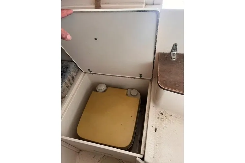 Slide: The Image of Storage compartment in a 2002 Grady-White Gulfstream 232 boat, featuring a yellow container. - 12