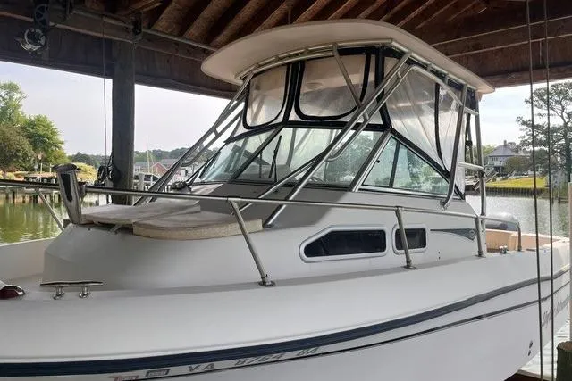 Slide: The Image of 2002 Grady-White Gulfstream 232 boat docked under a wooden shelter. - 2