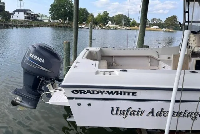 Slide: The Image of 2002 Grady-White Gulfstream 232 boat with Yamaha motor docked by a serene waterfront. - 4