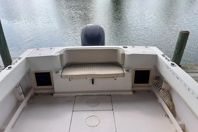 Slide: The Image of 2002 Grady-White Gulfstream 232 boat interior with seating, docked by calm water. - 6