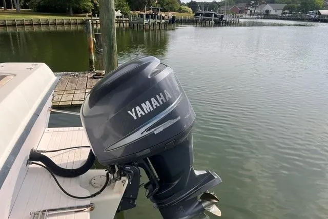 Slide: The Image of 2002 Grady-White Gulfstream 232 with Yamaha outboard motor docked by a serene waterfront. - 9