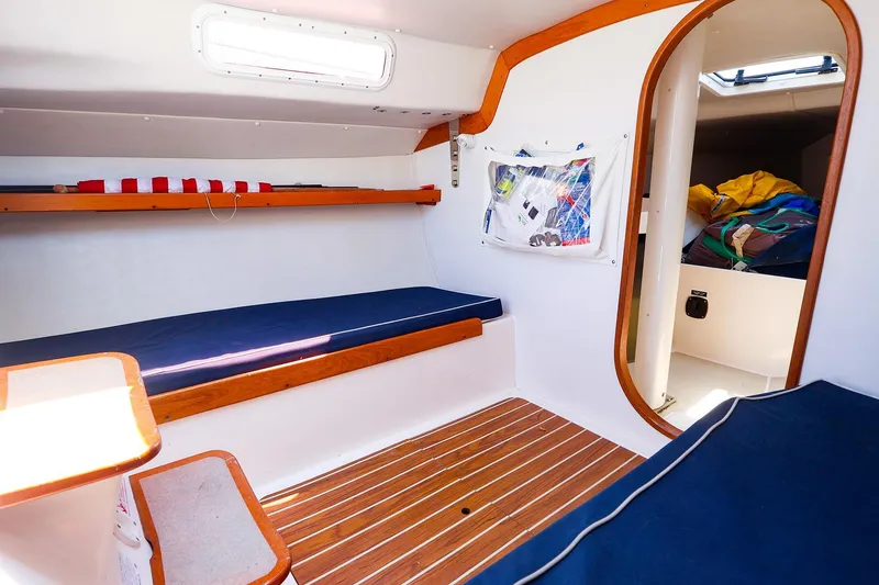 Slide: The Image of Interior of 2008 J Boats J/100 sailboat with wooden accents and blue cushions. - 17
