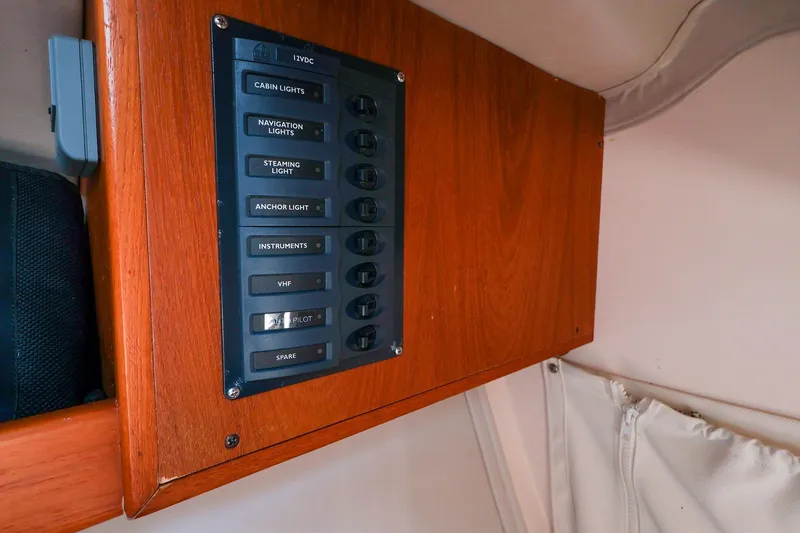 Slide: The Image of Electrical panel on 2008 J Boats J/100 sailboat, featuring various light and instrument switches. - 18