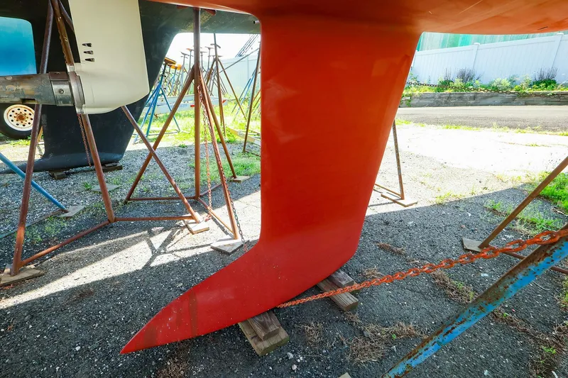 Slide: The Image of Red keel of a 2008 J Boats J/100 sailboat on stands in a boatyard. - 23