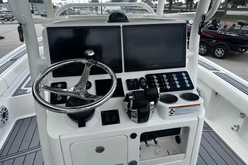 Slide: The Image of 2021 Caymas 28 HB boat dashboard with dual screens and steering wheel. - 12