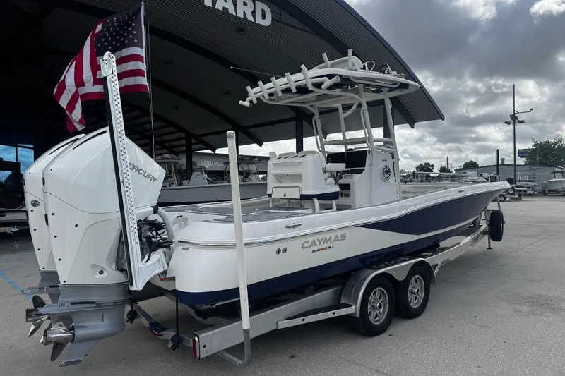 Slide: The Image of 2021 Caymas 28 HB boat with Mercury engine, parked on a trailer, American flag displayed. - 4